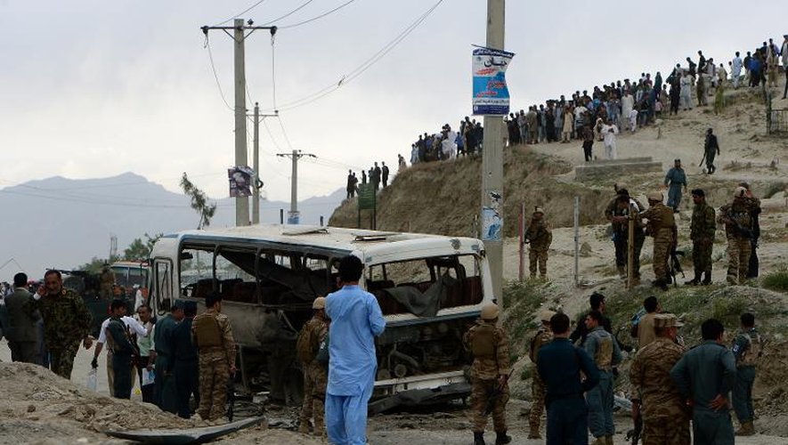 Inspection d'un bus ravagé par un attentat suicide à Kaboul, le 26 mai 2014