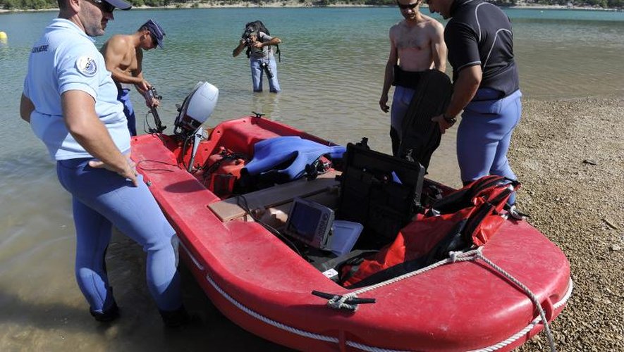 Des policiers d'apprêtent à reprendre les recherches de la famille disparue sur le lac de Sainte-Croix, le 17 août 2013