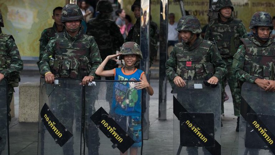 Un garçon se fait photographier avec des soldats à Bangkok près du Monument de la Victoire, récent lieu de manifestations contre le coup d'Etat, le 30 mai 2014