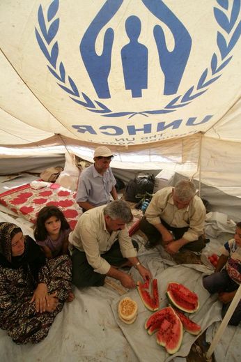Une famille de Kurdes syriens partagent une pastèque sous une tente, dans le camp de réfugiés de Quru Gusik près d'Erbil, la capitale du Kurdistan irakien