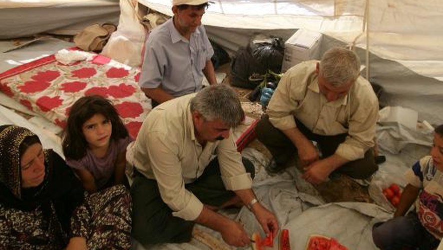 Une famille de Kurdes syriens partagent une pastèque sous une tente, dans le camp de réfugiés de Quru Gusik près d'Erbil, la capitale du Kurdistan irakien