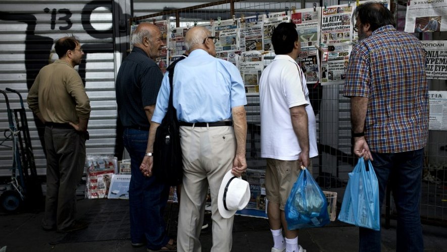 Des Grecs devant un kiosque à journaux le 11 juillet 2015 à Athènes