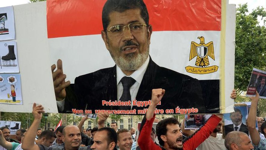Des manifestants tiennent un portrait géant de Mohamed Morsi, lors d'un défilé en soutien au président égyptien islamiste déchu, le 18 août 2013 à Paris