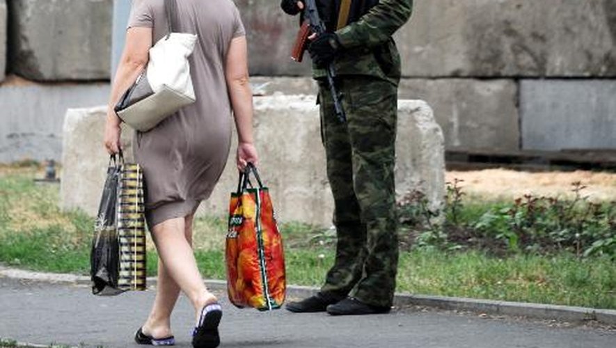 Une femme passe devant un checkpoint des insurgés prorusses, le 31 mai 2014 à Donetsk
