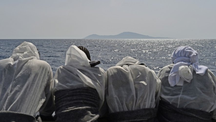 Des migrants regardent l'île de Pantelleria depuis le navire Aquarius après leur sauvetage en mer, le 25 mai 2016