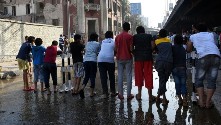 Des passants devant le consulat italien visé par un attentat-suicide le 11 juillet 2015 au Caire