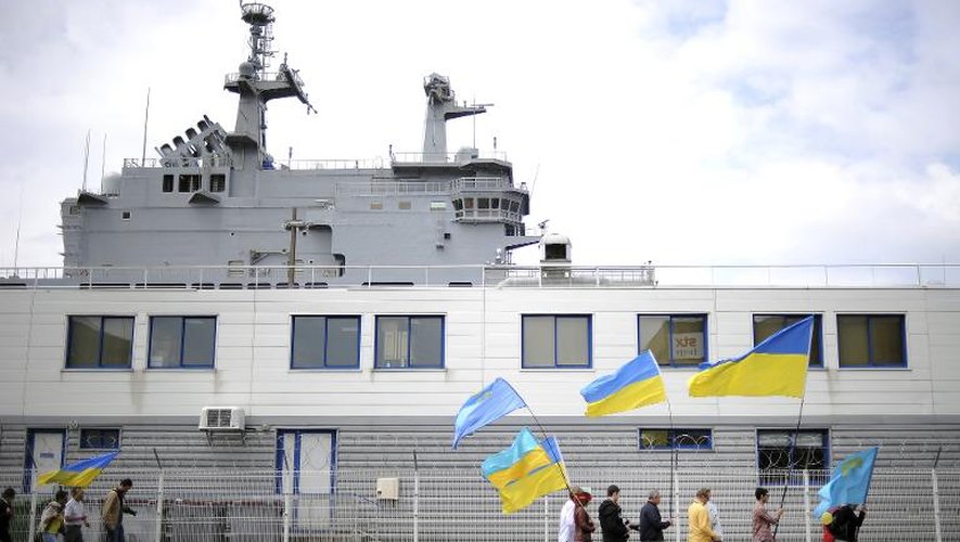 Quelques manifestants dimanche 1er juin à Saint-Nazaire, tenant un drapeau ukrainien, devant le "Vladivostok", navire de guerre construit par la France et devant être livré à la Russie