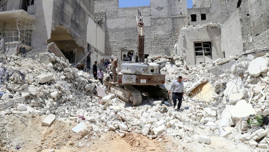 Des personnes inspectent les décombres après un bombardement aérien du régime syrien sur Alep, le 24 mai 2015