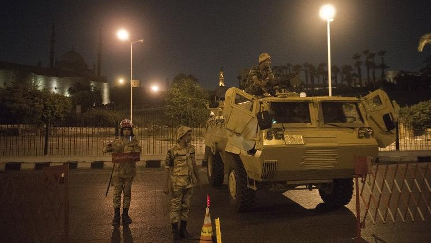 Des soldats égyptiens montent la garde à un barrage improvisé, lors du couvre-feu, dans la nuit du 19 au 20 août 2013 au Caire