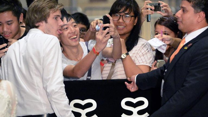 Le testeur de jeux vidéo suédois et star du web Felix Kjellberg, alias PewDiePie (g), pose avec un fan, le 23 mai 2013 à Singapour