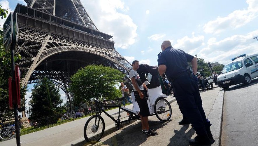 Un policier contrôle un vélo-taxi, à Paris le 14 août 2013