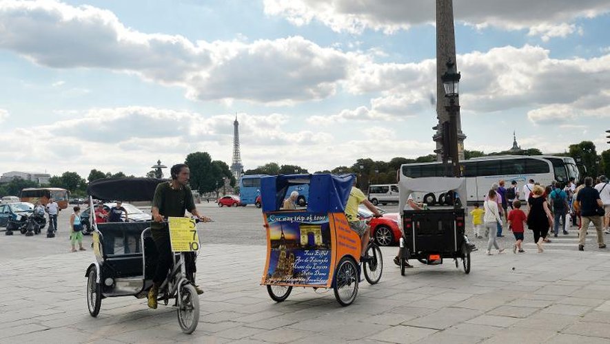 Des vélos-taxis place de la Concorde, à Paris, le 14 août 2013