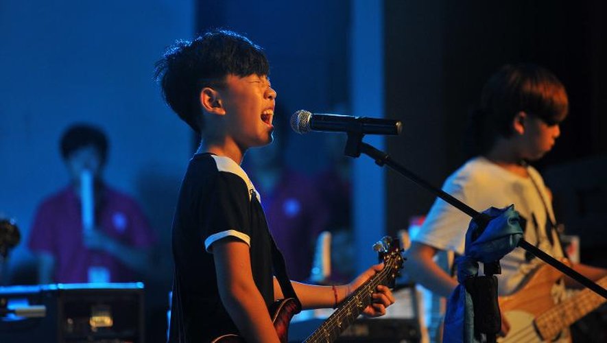 Un jeune garçon sur scène le 11 août 2013 lors d'une compétition pour rockeurs en herbe, à Tianjin, au nord de la Chine