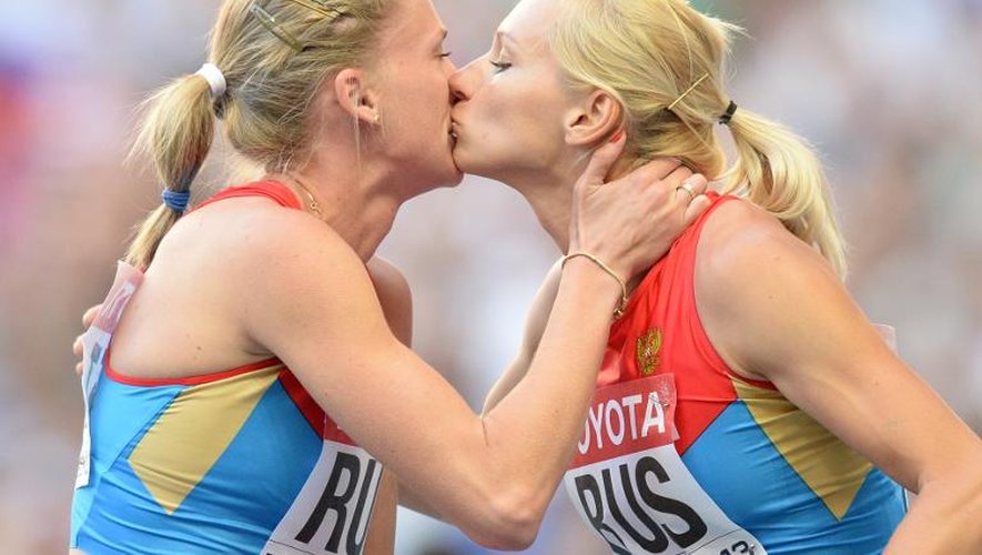 La Russe Kseniya Ryzhova (à gauche) embrasse sa compatriote Tatyana Firova (à droite) sur le podium après leur victoire dans le relais 4x400 m dames des Mondiaux d'athlétisme à Moscou le 17 août 2013