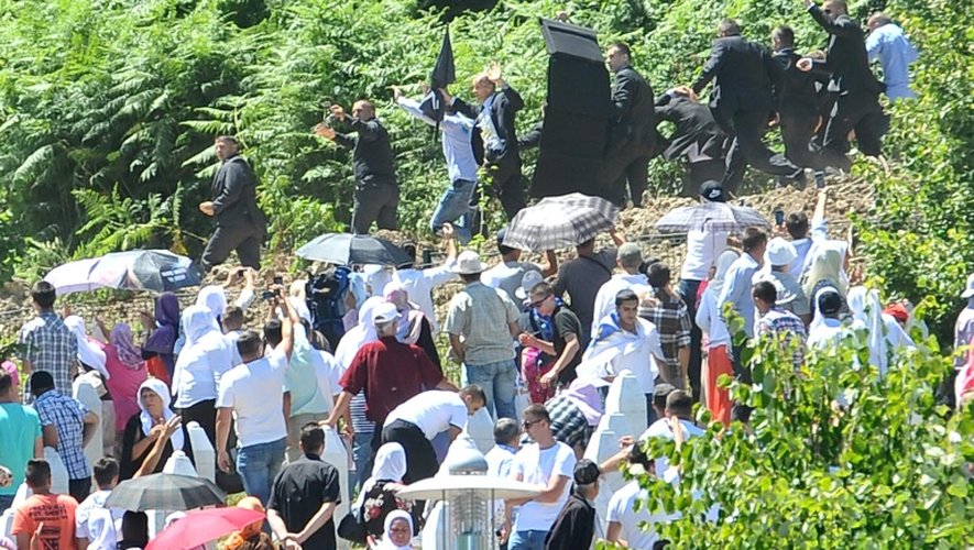 Le Premier ministre serbe Alexandar Vucic entouré de ses gardes du corps quitte en courant le mémorial Potoocari le 11 juillet 2015 à Srebrenica
