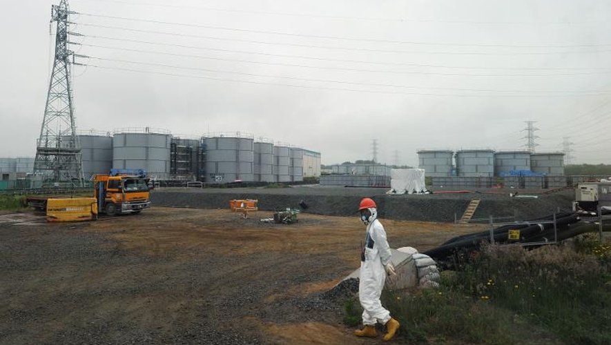 Un ouvrier marche à proximité des réservoirs d'eau de la centrale nucléaire de Fukushima, le 12 juin 2013
