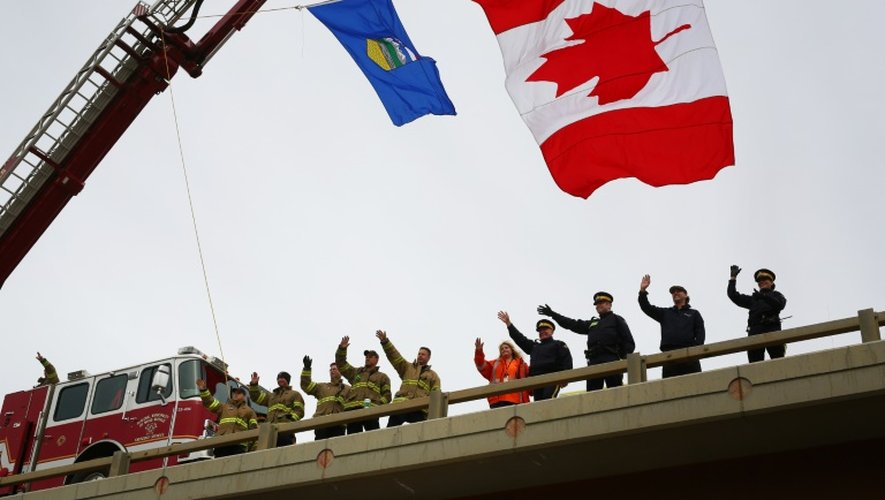 Des pompiers et policiers canadiens saluent le retour des habitants à Fort McMurray, le 1er juin 2016