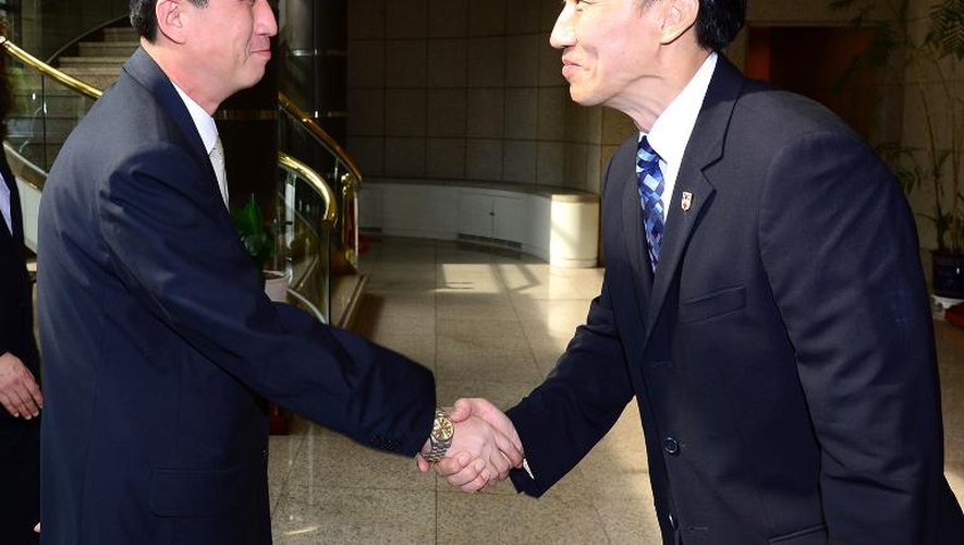 Le chef de la délégation nord-coréenne, Pak Yong-Il (g), sert la main de son homologue Lee Duck-Hang, le 23 août 2013 à Panmunjom
