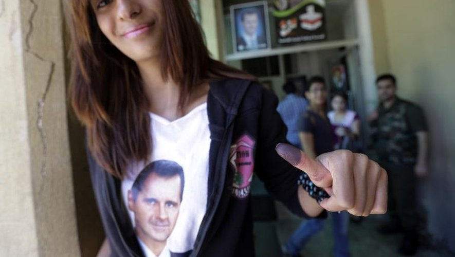 Une étudiante syrienne arborant un portrait de Bachar al-Assad sur son T-shirt vient de voter à Homs, le 3 juin 2014