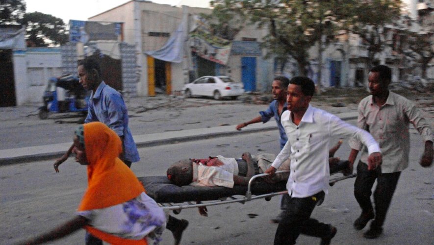 Des personnes évacuent un blessé après l'attaque contre l'hôtel Ambassador à Mogadiscio, le 2 juin 2016