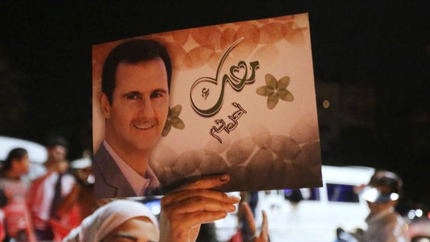 Une Syrienne brandit un portrait de Bashar al-Assad à Damas en célébrant sa victoire à l'élection, le 4 juin 2014