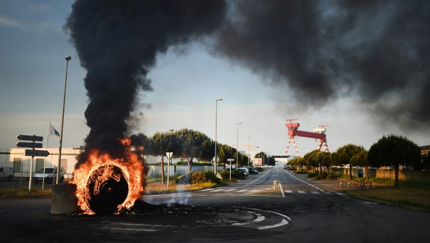 Des grévistes brûlent un pneu pour bloquer l'accès au port de Saint-Nazaire le 24 mai 2016