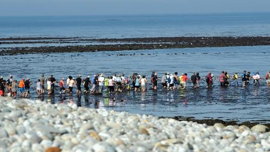 Des randonneurs traversent la mer de l'îlot de Triélen à l'île de Molène le 22 août 2013, dans le finistère