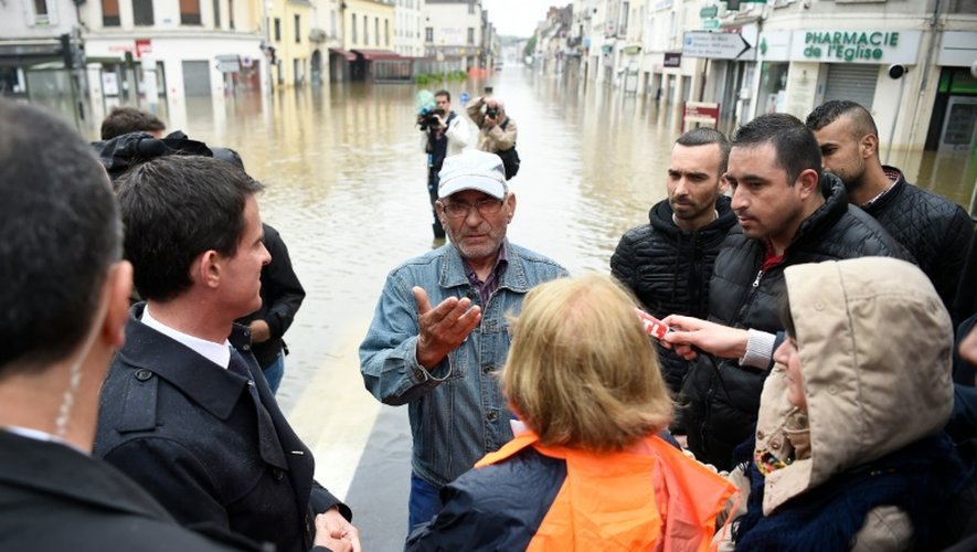 Le Premier ministre Manuel Valls écoute une victime des inondations à Nemours le 2 juin 2016