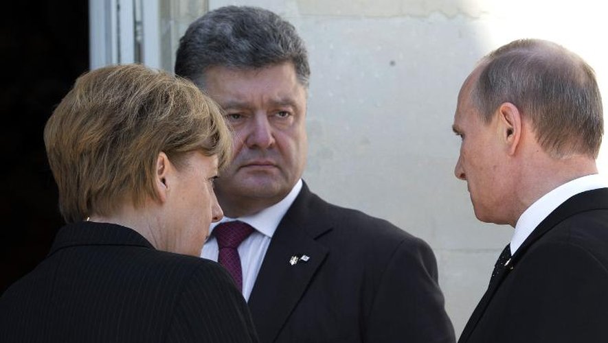 Le président ukrainien Piotr Porochenko (c) s'entretient avec le président russe Vladimir Poutine et la chancelière allemande Angela Merkel, lors de l'anniversaire du Débarquement le 6 juin 2014 au Chateau de Benouville