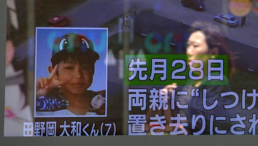 Un piéton passe devant un écran de télévision montrant le petit garçon disparu au Japon, le 3 juin 2016