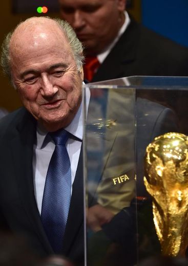 Sepp Blatter pose à proximité du trophée de la Coupe du monde après une conférence de presse, le 5 juin 2014 à Sao Paulo
