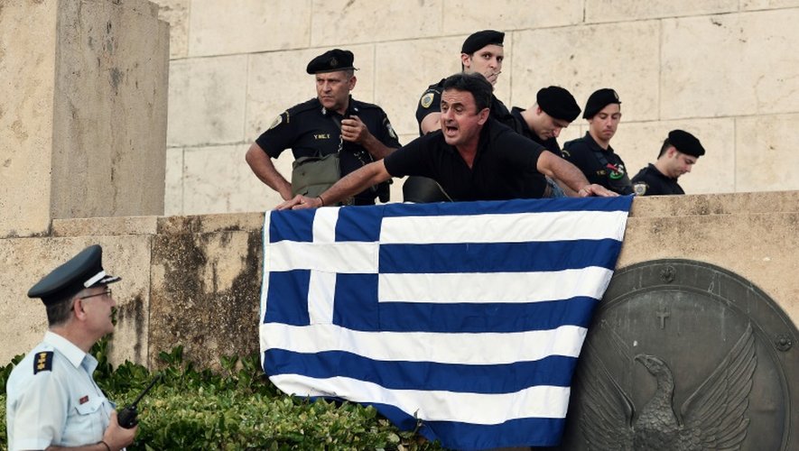 Un manifestant brandit, le 13 juillet 2015 le drapeau grec lors d'une manifestation à Athènes opposée à l'accord financier conclu à Bruxelles