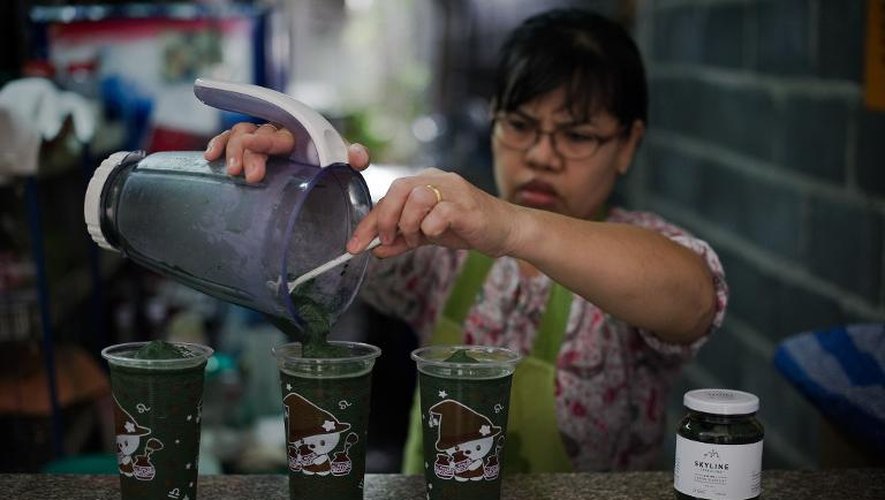 Une femme sert une boisson à la spiruline, le 24 juin 2013 à Bangkok