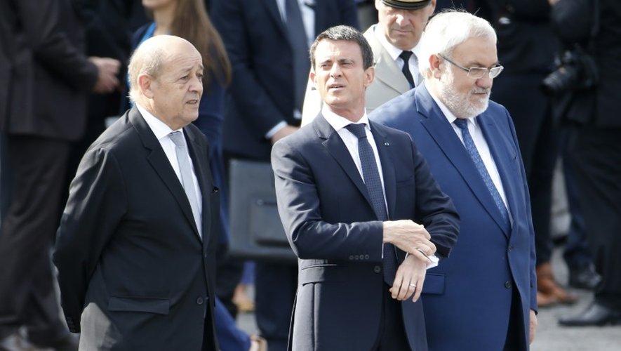 (G à D): le ministre de la Défense Jean-Yves Le Drian, le Premier ministre Manuel Valls et le Secrétaire d'État chargé des Anciens Combattants et de la Mémoire Jean-Marc Todeschini, sur les Champs-Elysées le 14 juillet 2015