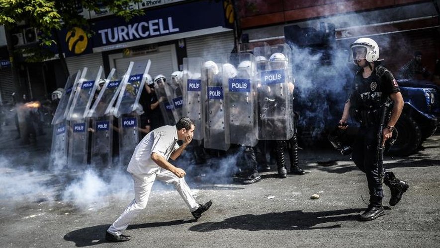 Un militant kurde se heurte aux policiers anti-émeutes turcs lors d'une manifestation le 8 juin 2014, dans le quartier de Bagcilar à Istanbul