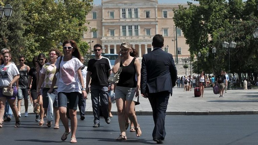 Des personnes marchent dans le centre d'Athènes à proximité du parlement, le 27 août 2013