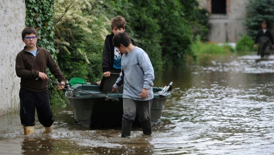 De jeunes gens tirent un bateau dans une rue inondée à Monthou-sur-Bievre (Loir-et-Cher le 3 juin 2016