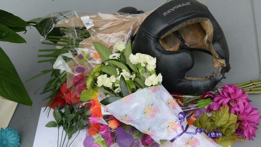Un casque de boxe, des fleurs sont deposés comme des souvenirs, le 4 juin 2016 devant la maison où a grandi Mohamed Ali à Louisville
