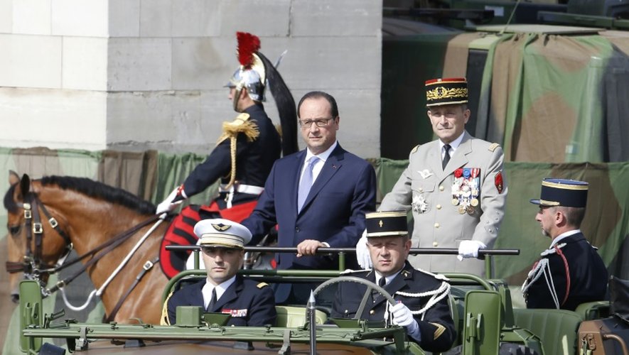 Le président français François Hollande (c) et le chef d'état-major des armées, le général Pierre de Villiers sur un véhicule militaire durant le défilé du 14 juillet 2015 à Paris