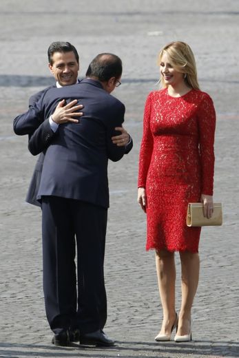 Le président français François Hollande (c) embrasse son homologue mexicain Enrique Pena Nieto (g), aux côtés de la Première dame mexicaine Angelica Rivera le 14 juillet 2015 à Paris