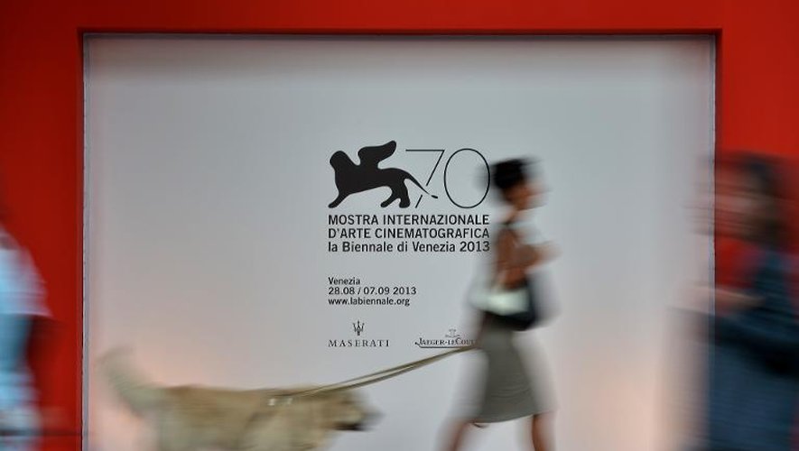Une femme passe devant l'affiche de la 70e Mostra de Venise, le 27 août 2013