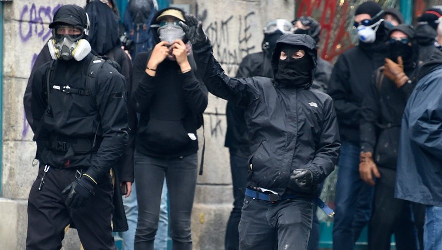 Des protestataires lancent des pierres contre la police anti-émeutes le 4 juin 2016 à Paris pendant une marche des "antifascistes" à la mémoire du militant d'extrême gauche Clément Méric