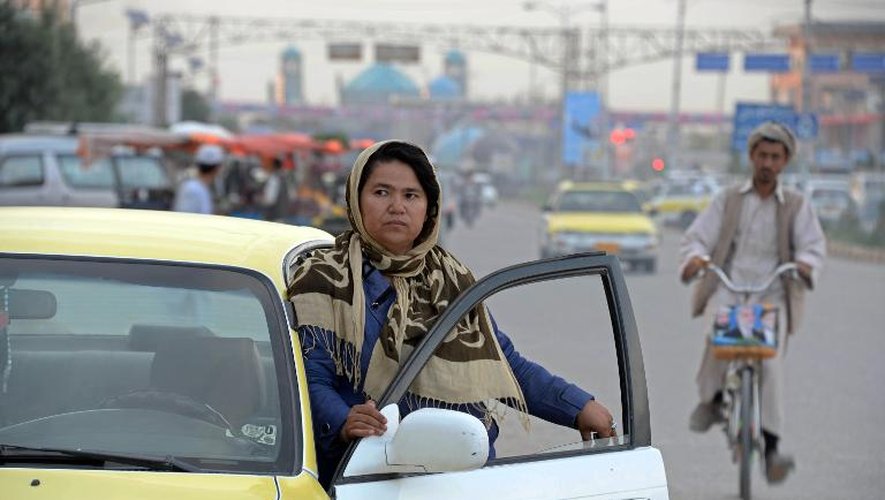 Sara circule dans les rues de Mazar-i-Sharif, grande ville et poumon économique du nord afghan, au volant de son taxi jaune et blanc