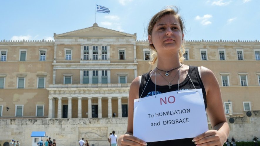 Une manifestante proteste contre les mesures d'austérité prévues dans l'accord signé avec les créanciers devant le Parlement grec à Athènes, le 15 juillet 2015
