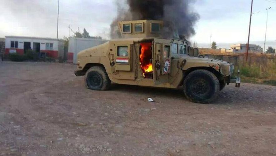 Photo prise d'un véhicule blindé de l'armée irakienne en feu, le 10 juin 2014 à Mossoul, deuxième ville du pays, contrôlée désormais par les jihadistes