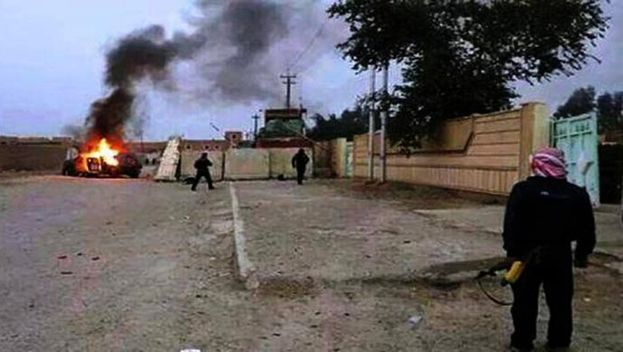 Photo prise le 10 juin 2014 à Mossoul, en Irak, avec un téléphone portable et montrant un véhicule en flammes alors que les jihadistes ont pris le contrôle de la deuxième ville du pays