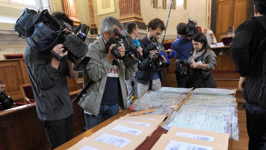 Des journalistes filment des preuves matérielles disposées sur une table à l'ouverture du procès du médecin urgentiste  Nicolas Bonnemaison, aux assises de Pau, le 11 juin 2014