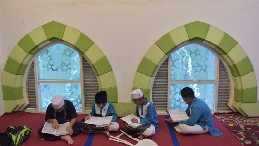Des jeunes musulmans indonésiens lisent le Coran, le 6 juin 2016 dans une mosquée à Tangerang en ce premier jour du mois de ramadan