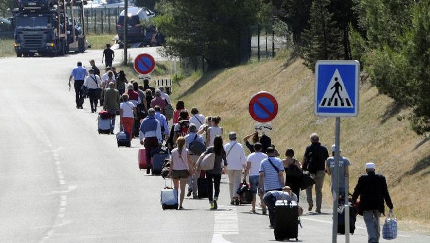 Des personnes quittent à pied l'aéroport de Marseille-Marignane alors que les taxis sont en grève, le 11 juin 2014