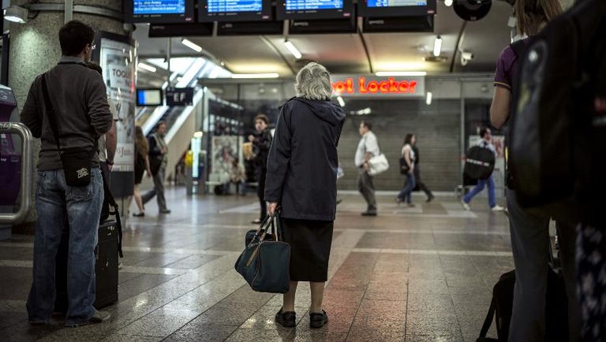 Des personnes regardent des panneaux d'affichage de la SNCF dans la gare Part-Dieu à Lyon, le 11 juin 2014